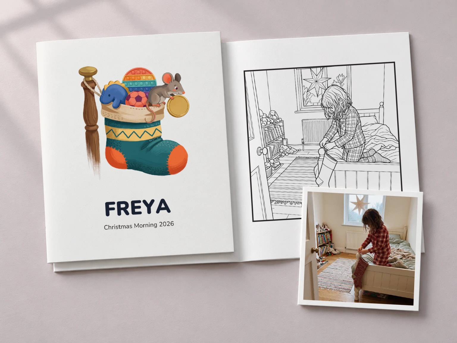 A Christmas colouring book with a stocking full of toys and the name Freya on its cover, beside the open page of a girl hanging a stocking on her bedpost, with the photo it was drawn from as a print.